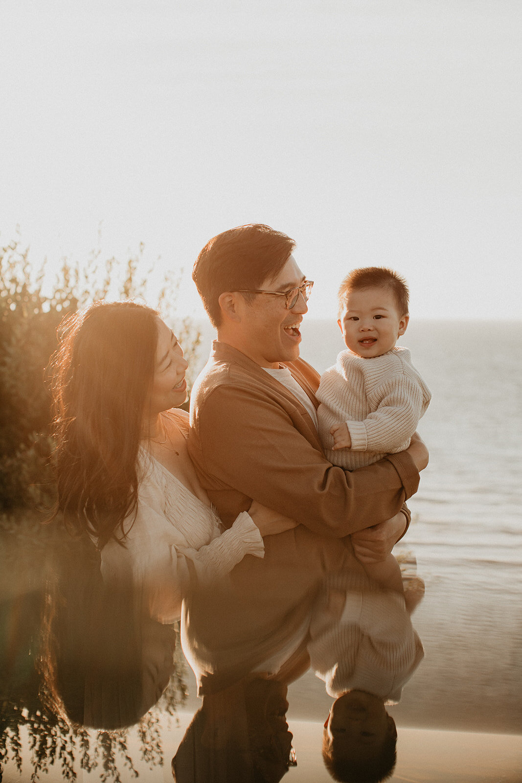 Family making a heart shape with their hands in warm golden light