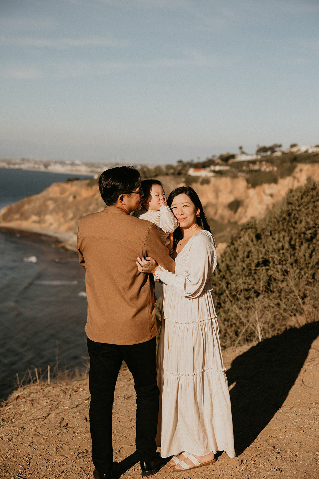 Couple walking the coast, mother in a flowing maternity gown